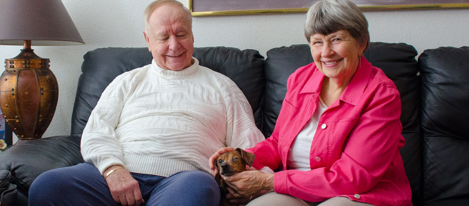 residents on couch with small dog