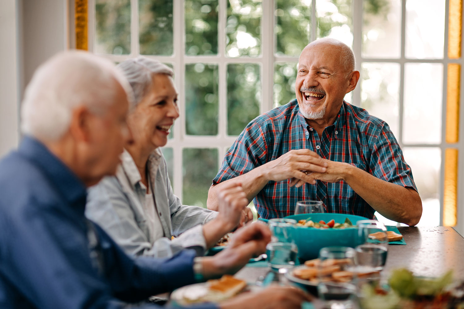 Senior friends laughing over dinner