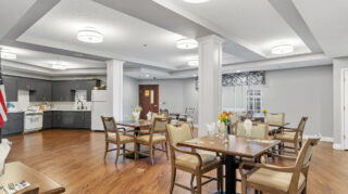 Regent at Burnsville Care Suites, view of dining room and kitchen, warm lighting and comfortable seating